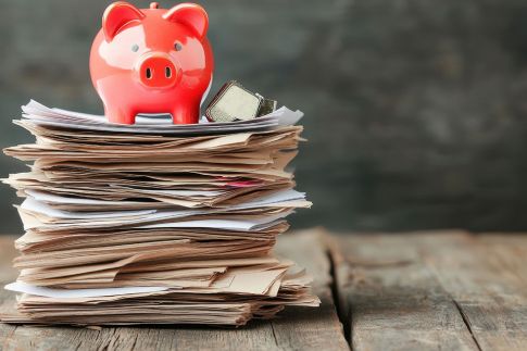 Foto: Rotes Sparschwein auf Aktenstapel